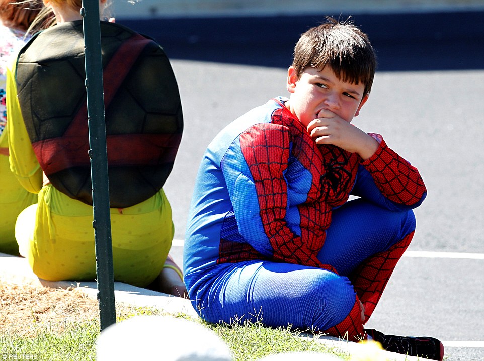 A young boy dressed as Spider-Man watches as Jacob's casket leaves the church after the funeral service in Townville