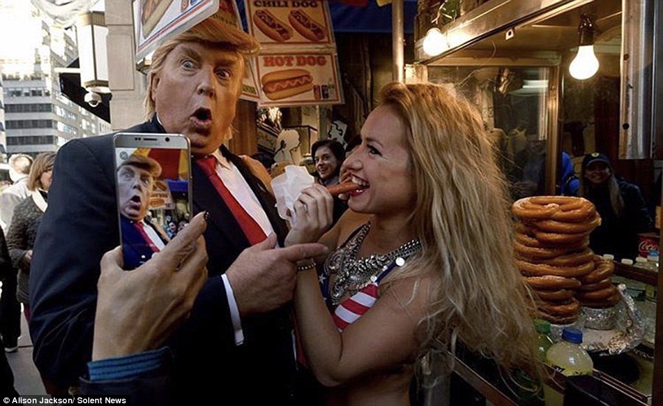 One photo shows a Donald lookalike posing at a hot dog stand with a woman as she eats a sausage at the book launch