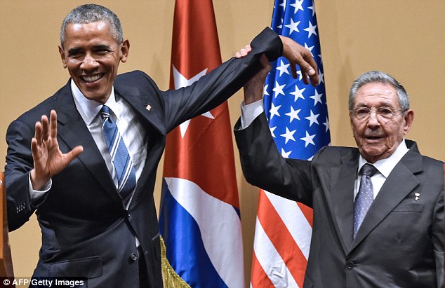 Allies: Cuban President Raul Castro, right, raises US President Barack Obama's hand during a meeting at the Revolution Palace in Havana in March, which marked a thaw in US-Cuba relations - a deal which Donald Trump has said he will back away from 