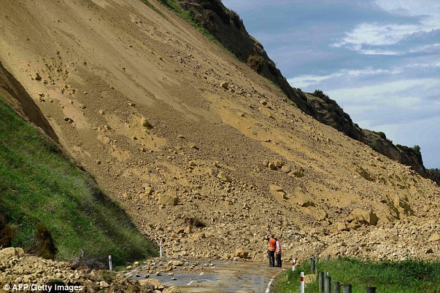Emergency services officers inspect the immense damage caused to Rotherham Road near Waiau town, 90 kilometres south of Kaikoura