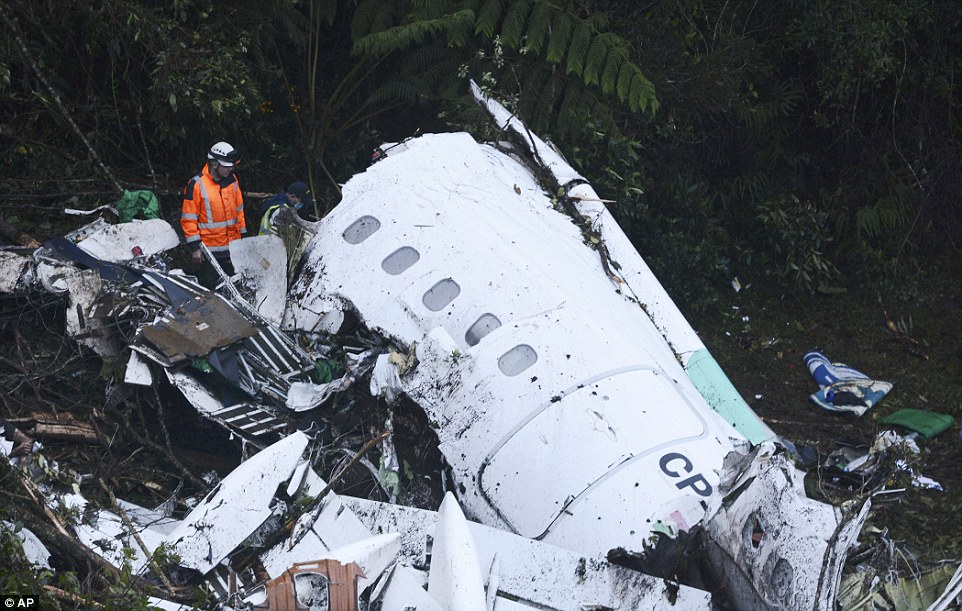 A rescue worker inspects the shattered fuselage of the plane that came down in a mountainous part of Colombia
