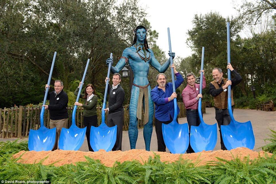 Using Na'vi-inspired shovels and assisted by a Na'vi  (left to right) George Kalogridis, president of Walt Disney World Resort; Meg Crofton, president of Walt Disney Parks and Resorts Operations, United States and France; Tom Staggs, chairman, Walt Disney Parks and Resorts;  Jon Landau, Avatar producer; Bruce Vaughn, chief creative executive of Walt Disney Imagineering and Joe Rohde, creative executive, Walt Disney Imagineering, pose during the ceremonial groundbreaking of the Avatar land