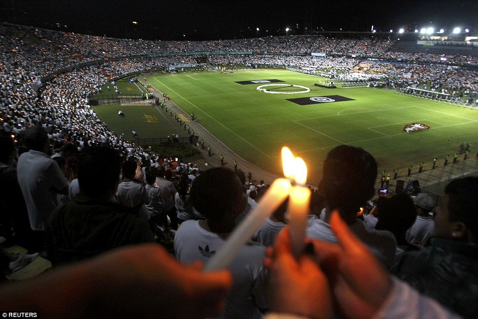 As the probe into the devastating crash continued, mourning soccer fans in Medellin and the southern Brazilian town of Chapeco, where the team is from, held simultaneous stadium tributes to the victims. Atletico Nacional fans are pictured holding candles as part of a tribute