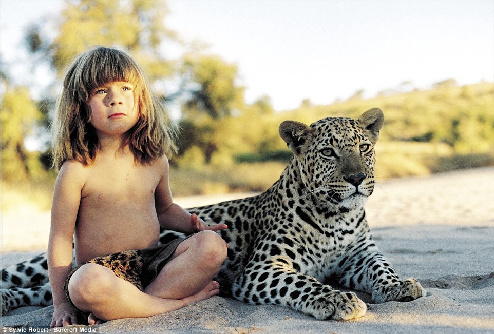 Tippi, aged 6, sitting with J&B, a tame adult leopard in she met in Namibia, during her extraordinary childhood