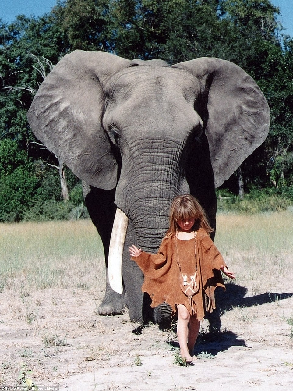 Tippi is pictured in front of 34-year-old elephant Abu in Botswana at the age of six