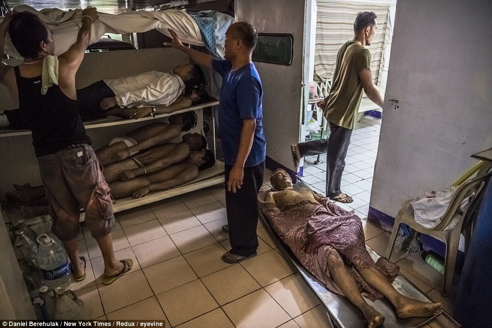 Bodies stacked up at a funeral parlor as the families of victims like Danilo Deparine, whose body lay on a metal stretcher on the floor, struggle to pay for burial, in Manila, Philippines
