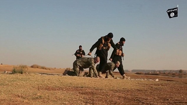 The Turkish soldiers are walked like dogs by two ISIS militants, who appear unmasked and wearing black clothing, brown suicide belts and carrying assault rifle