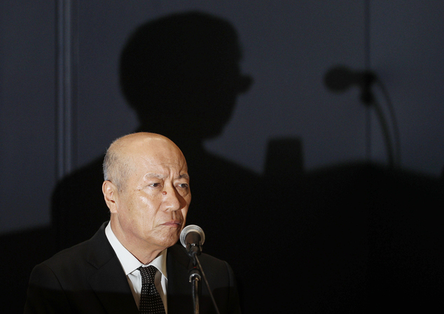 Dentsu Inc. president Tadashi Ishii tell reportors he will resign over the suicide of a worker who had clocked massive overtime. (Kyodo News via Associated Press image)