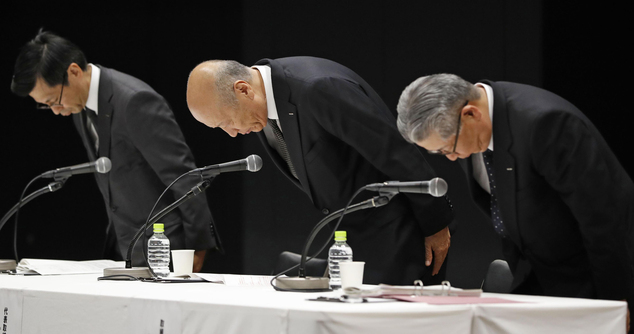 Dentsu Inc. president Tadashi Ishii, pictured centre, bows with other senior executives during a media conference at the company's Tokyo headquarters (Kyodo News via AP)