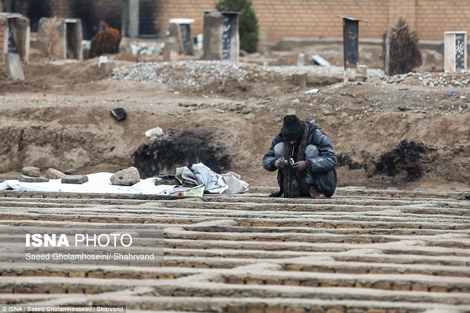 A man crouched above a grave in the cemetery 12 miles from Tehran, in images which have sparked an outcry in Iran