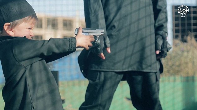 The child is seen walking over to the prisoner and handed a gun by the man in the background