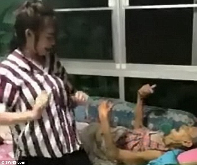 Ploy Theerada Mokkhasak, 23, performs the enthusiastic routine to bedridden Sumlee, 79, when she visits her at the family home in Prachin Buri, Thailand