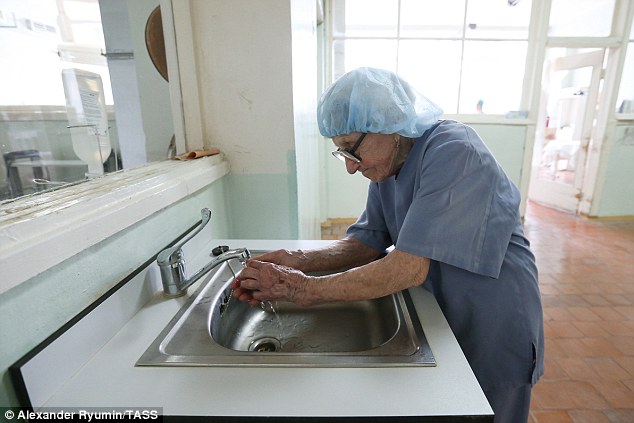 The experienced physician scrubs up in a hair net before going into perform surgery