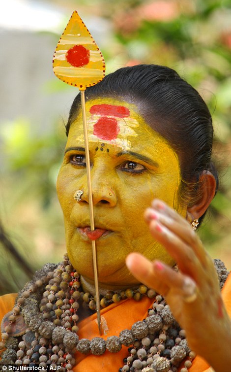 A self-proclaimed 'god woman' with a spear piercing her tongue participates in the Pooram Festival in Kerala, India