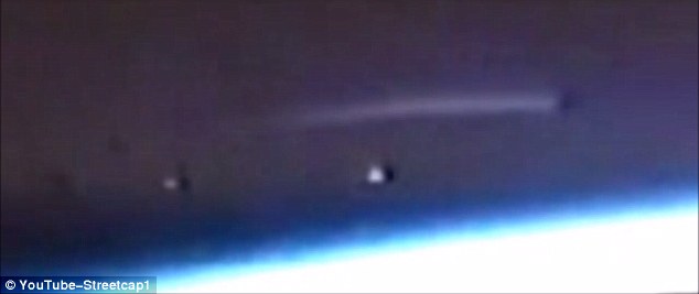 A video uploaded to YouTube by conspiracy theorist Streetcap1 shows a long bright light hovering above earth with two mysterious bright objects just below