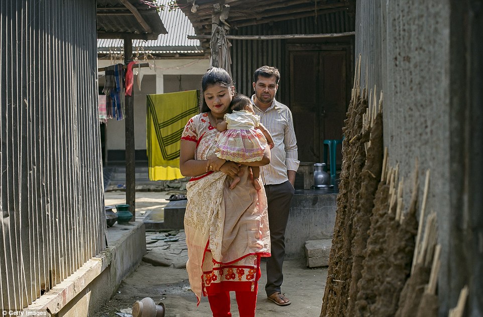 Meghla and Liton walk with their baby girl in the city of Khulna, Bangladesh. She gave birth two months ago
