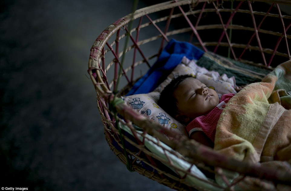 Meghla's two-month-old baby sleeps in a cot. She is the latest female in a family full of under-age marriages