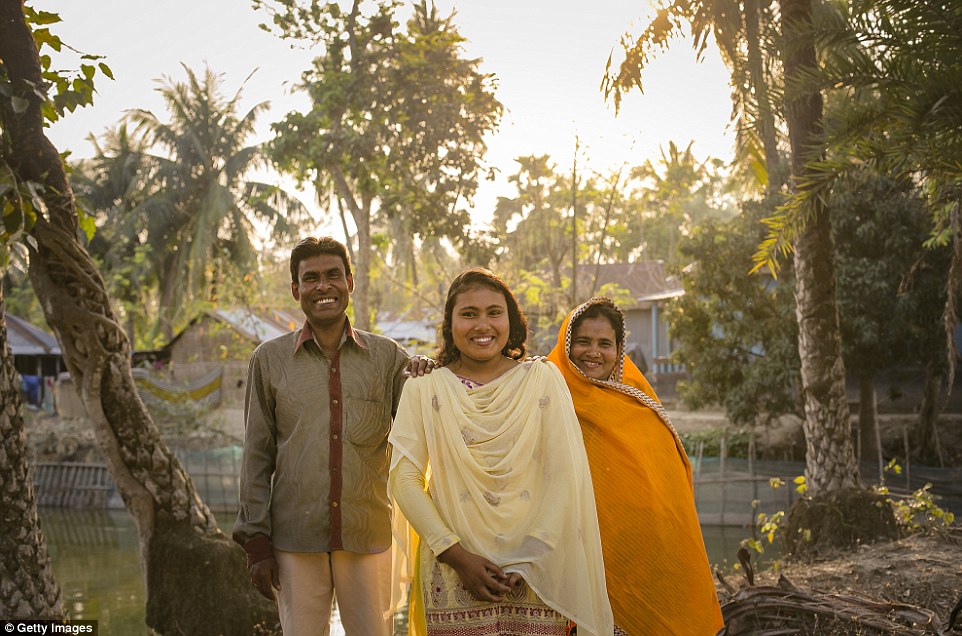 Rani, 16, poses with her father Abdul and mother Pori. Rani was put under pressure to marry a boy when she was 14 despite the reluctance of her and her father