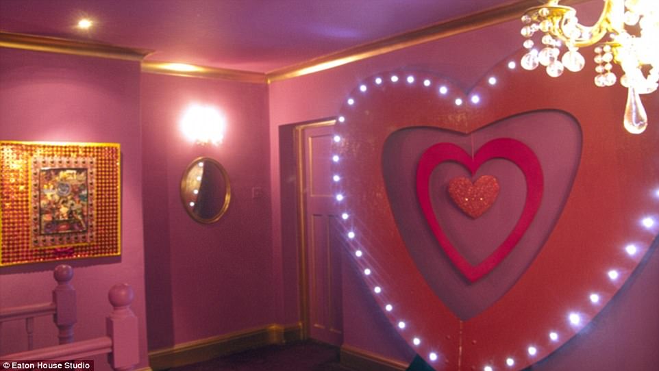 A giant red heart sculpture complete with spotlights decorates a wall
