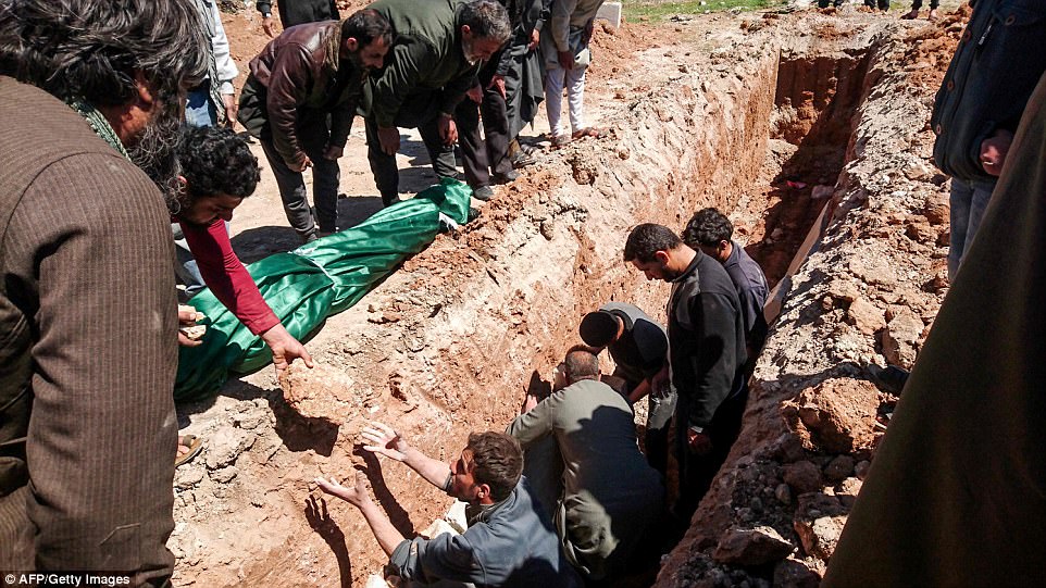 Syrians dig a grave to bury the bodies of victims of a a suspected toxic gas attack in Khan Sheikhun, a nearby rebel-held town in Syrias northwestern Idlib province