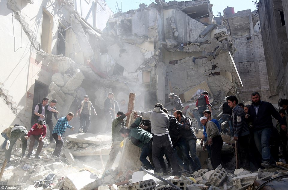Search and rescue team members, along with civilians, remove the debris as they try to locate survivors after Assad Regime's airstrike over residential areas in Saqba Town of Eastern Ghouta Region of Damascus, Syria, on Tuesday. At least four civilians, including two children killed and ten others were wounded in the attack