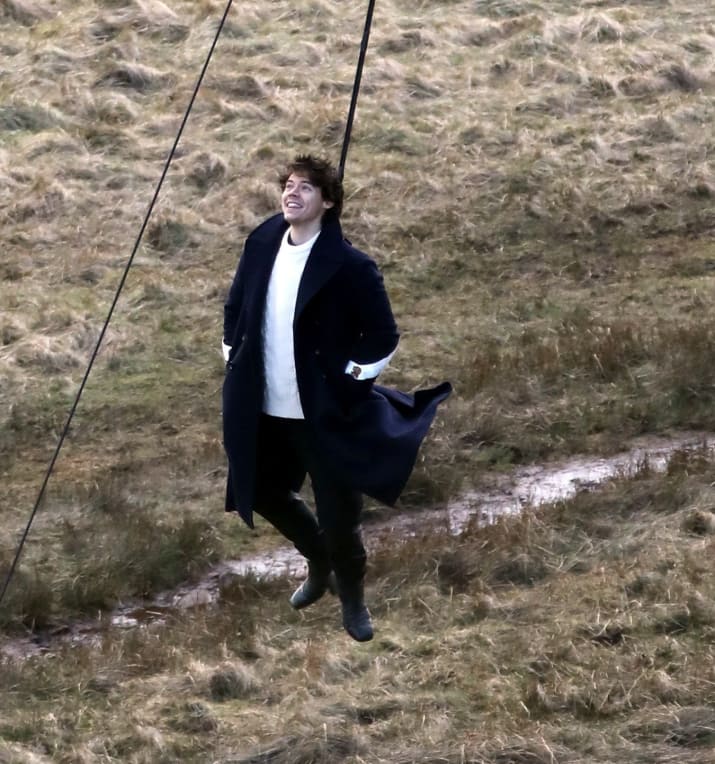 Here he is on some farmland in England about to dangle from a helicopter and looking pretty happy about it.