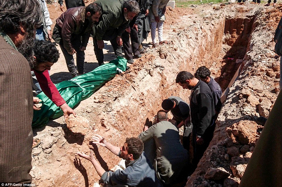 Syrians dig a grave to bury the bodies of victims of a suspected toxic gas attack in Khan Sheikhun, a nearby rebel-held town in Syrias northwestern Idlib province