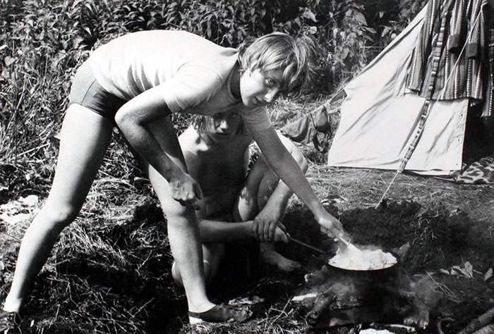 Angela Merkel Prepares A Meal On A Campfire While Camping With Friends In Himmelpfort, German Democratic Republic In July 1973