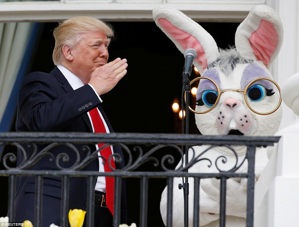 Trump salutes a member of the military who had just sung the U.S. national anthem as he stands with a performer in an Easter Bunny costume at the White House Easter Egg Roll on the Truman Balcony