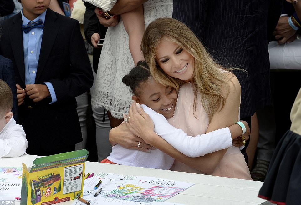 The first lady embraced a young girl as they colored cards together for members of the United States military 