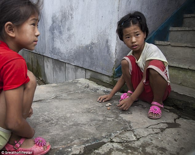 Left behind: Hyeonseo openly regards the country of her birth as the 'most horrible on earth' and its people the most brainwashed. Pictured: Two young girls play on the streets of North Korea