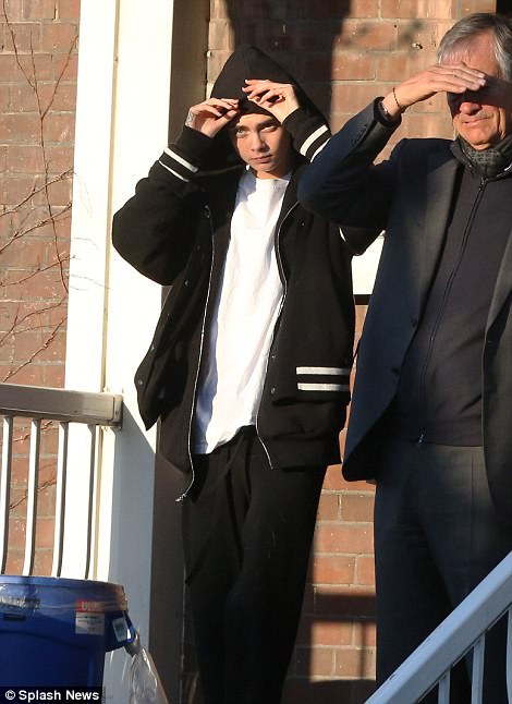 Casual: Later on Cara was seen dressed in an over-sized black varsity jacket as she shot further scenes for the film - pulling the hood above her head to conceal her new style