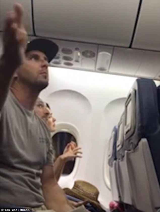 Brian Schear is seen remonstrating with airline staff after being told his son would have to relinquish his seat