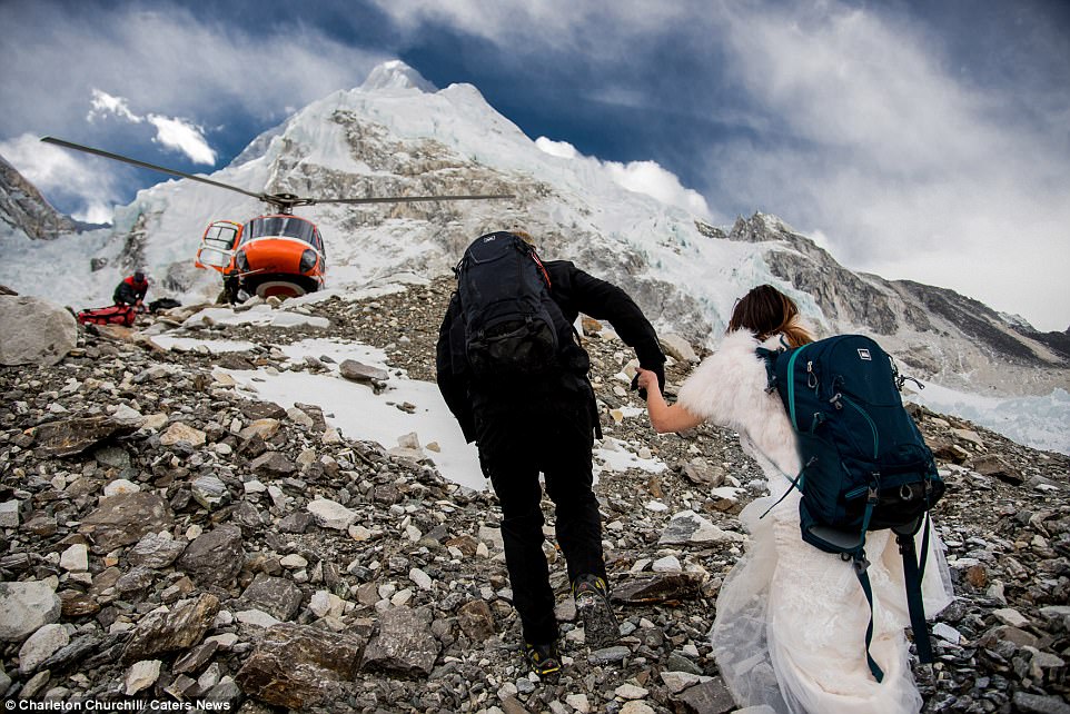 Helping hand: James reaches back for Ashley as the couple trek up the rocky mountain face towards a waiting helicopter