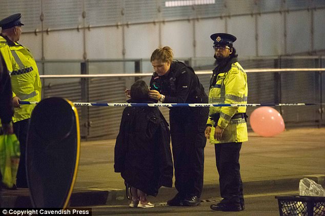 One touching image to emerge from the scenes of chaos and devastation shows a female police officer gently draping her coat over the shoulders of a little girl