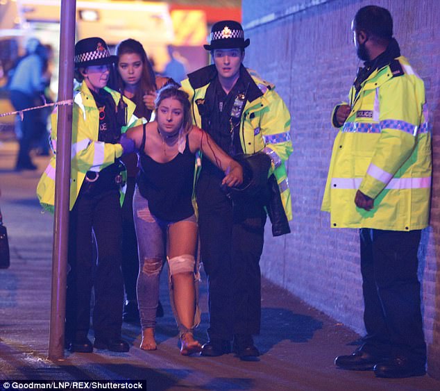 The masked jihadi, who sat with a sign which read 'Manchester 2017-05-02', was the latest ISIS sympathisers to celebrate the atrocity. Pictured: A victim is escorted from Manchester Arena