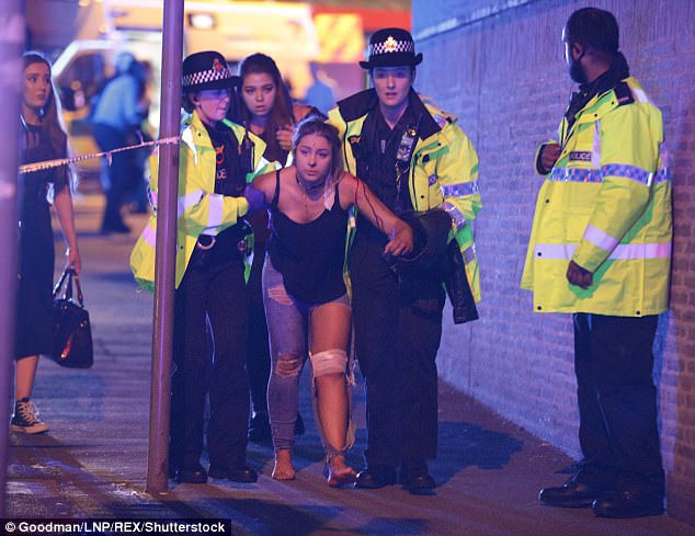 Police and other emergency services help an injured young woman after the suicide bomb 