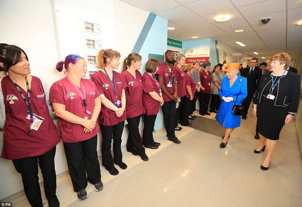 Proud: Staff lined the corridor as the Queen made her way through the building this morning, escorted by Kathy Cowell, right Chairman of the Central Manchester University Hospital. She said the level of community spirit shown had been 'splendid'