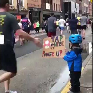 小男孩舉自製加油板子　馬拉松選手一看竟「搶著去碰」：速度變快了！
